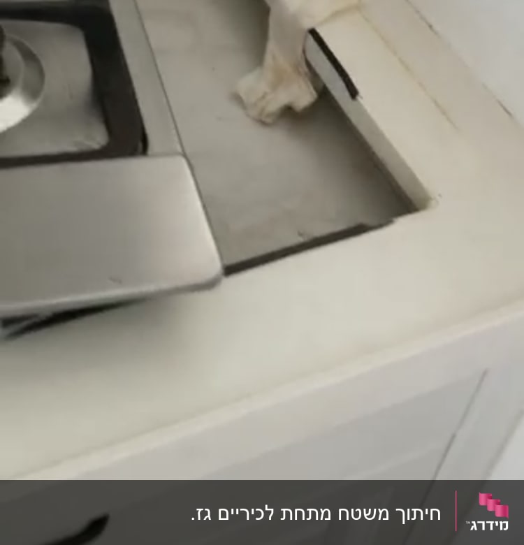 חיתוך שיש ליד כיריים במטבח